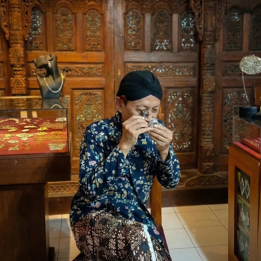 Priyana Jatmika Salim looking at silver ring with his loupe